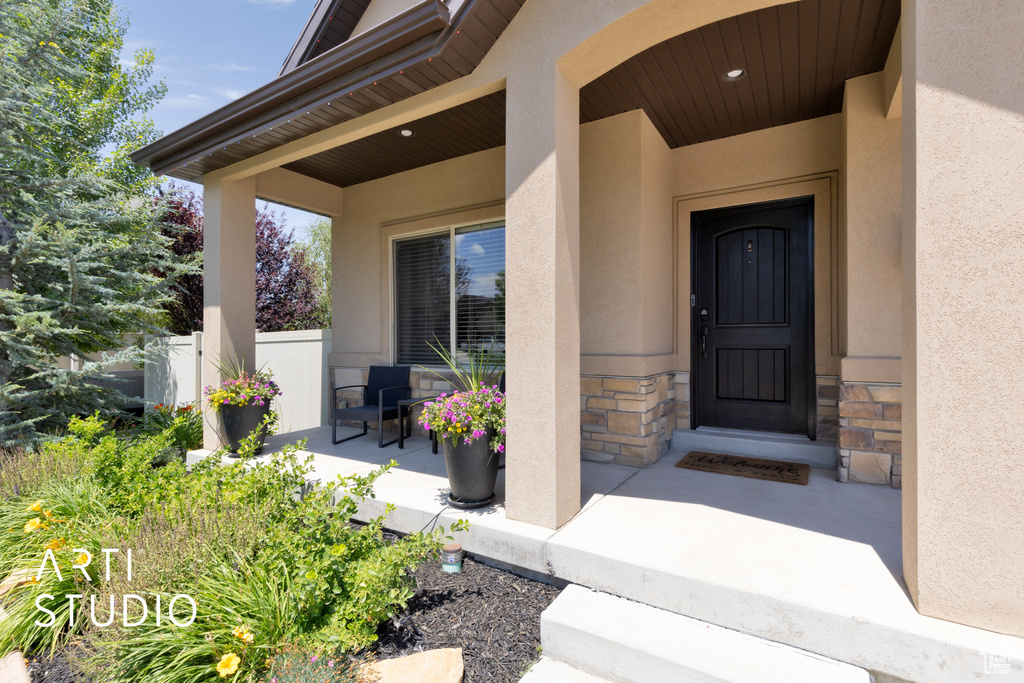 Entrance to property with stone siding and stucco siding