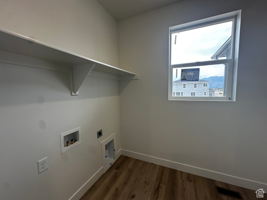 Laundry area with hookup for an electric dryer, dark wood finished floors, and hookup for a washing machine