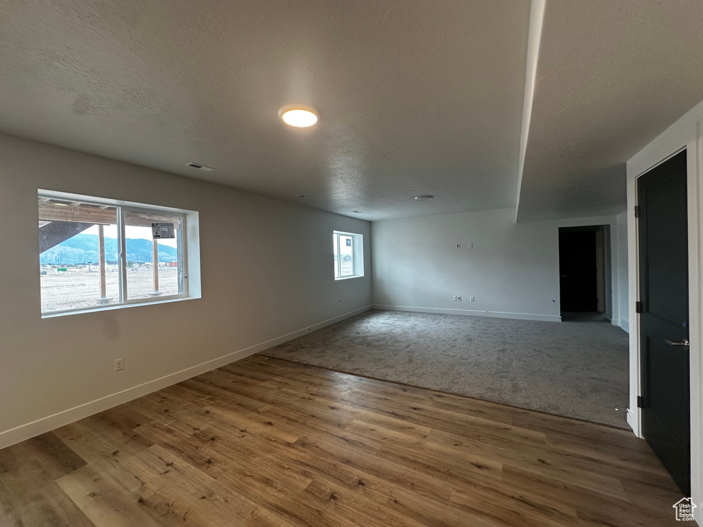 Spare room with wood finished floors and a textured ceiling