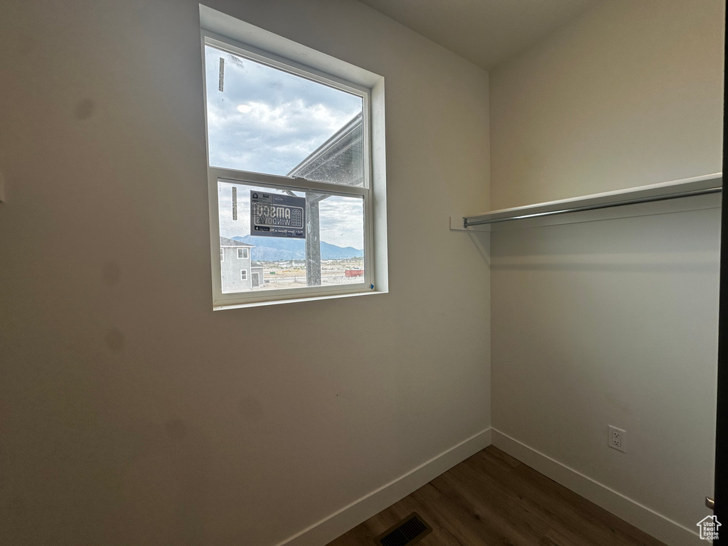 Walk in closet featuring dark wood finished floors