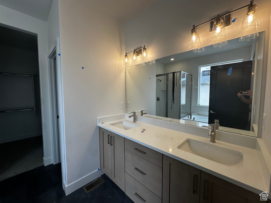 Bathroom with a shower stall, double vanity, and a garden tub