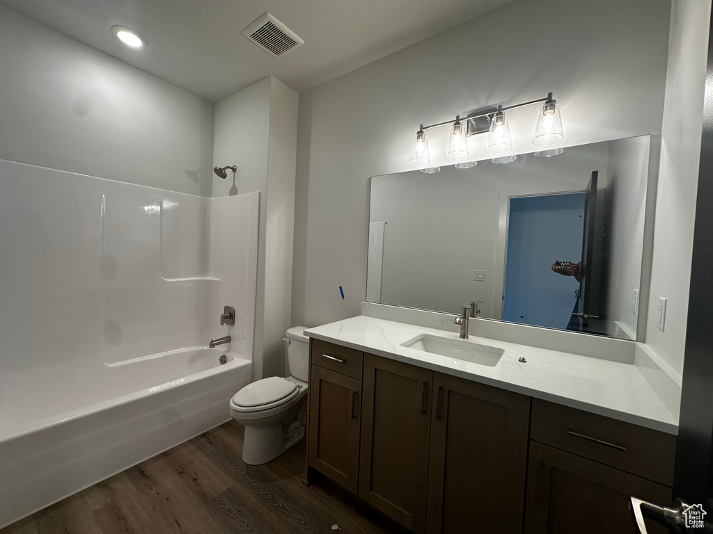 Full bath with wood finished floors, vanity, and bathing tub / shower combination