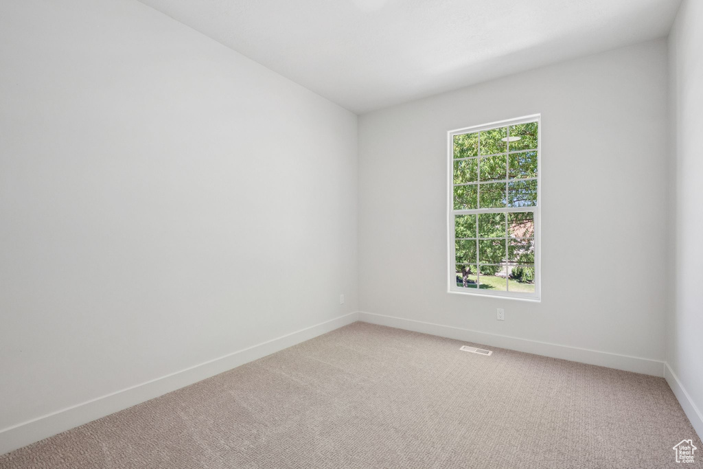 Unfurnished room featuring light carpet