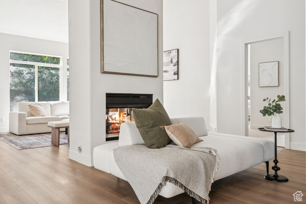 Bedroom featuring wood finished floors and a multi sided fireplace