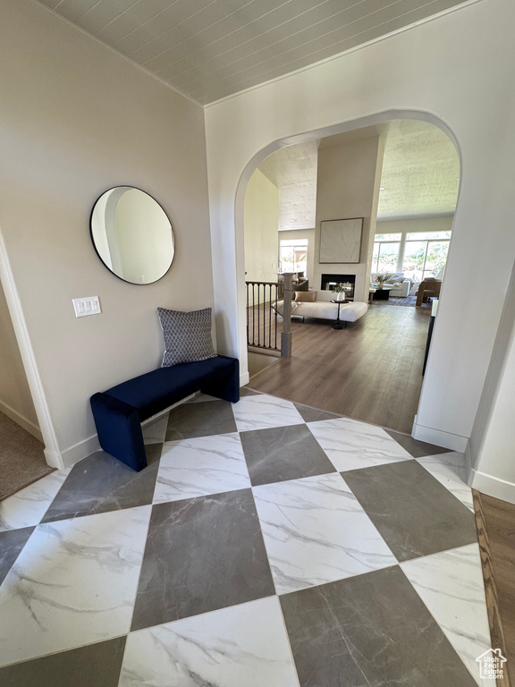 Corridor featuring arched walkways and marble finish floors
