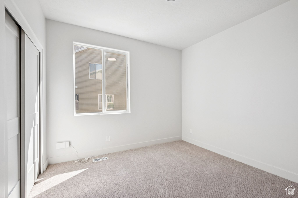 Unfurnished bedroom featuring carpet floors and a closet