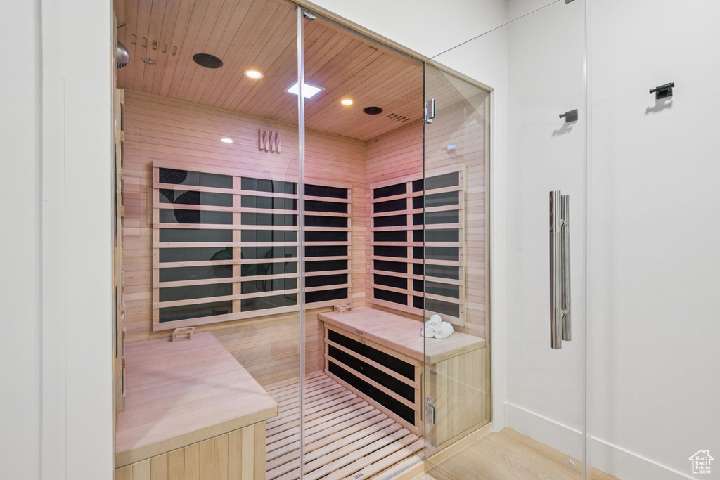 Relaxing sauna / steam room with recessed lighting, wood finished floors, and wooden ceiling