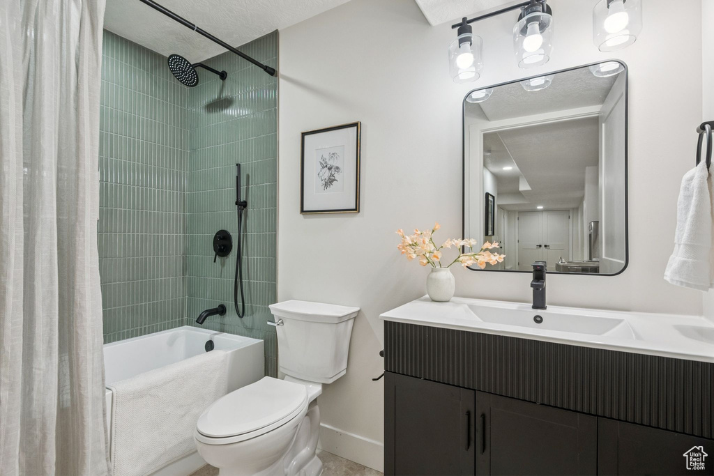 Full bathroom featuring shower / tub combo, vanity, and a textured ceiling