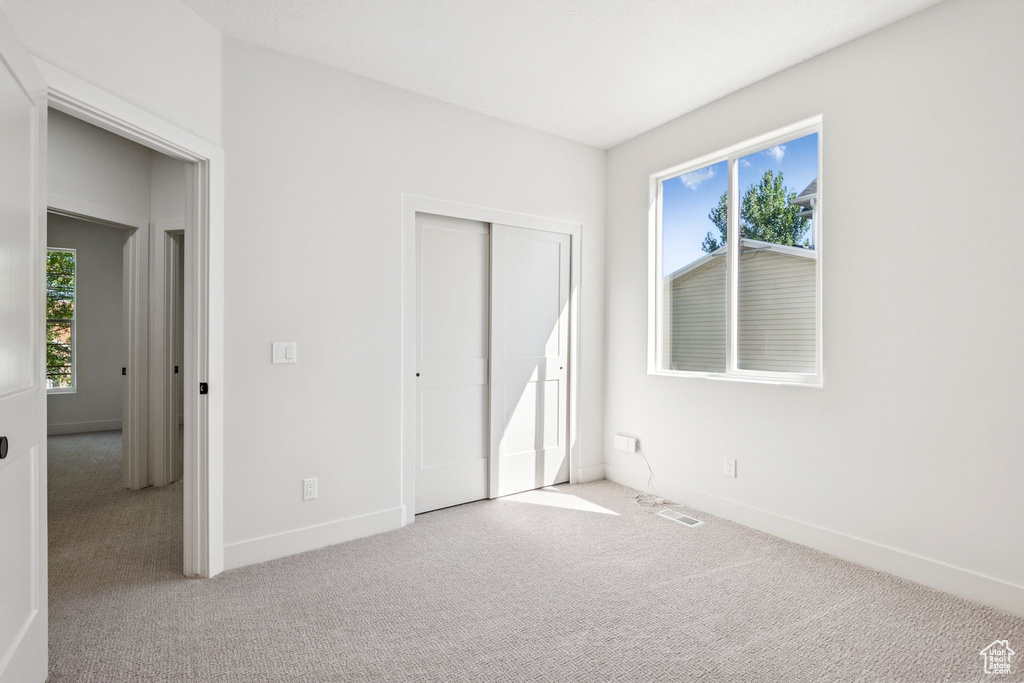 Unfurnished bedroom with carpet floors and a closet