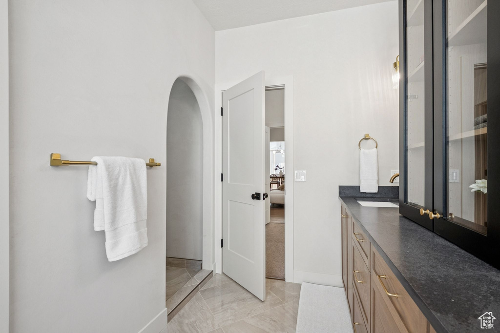 Full bathroom featuring vanity and marble finish flooring