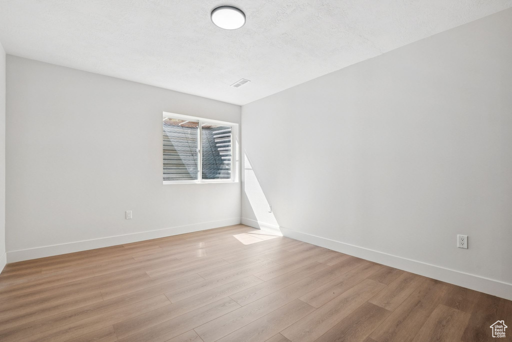 Empty room with light wood-style floors and baseboards