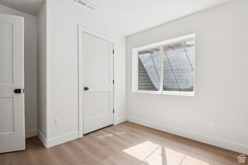 Unfurnished bedroom with baseboards and light wood finished floors