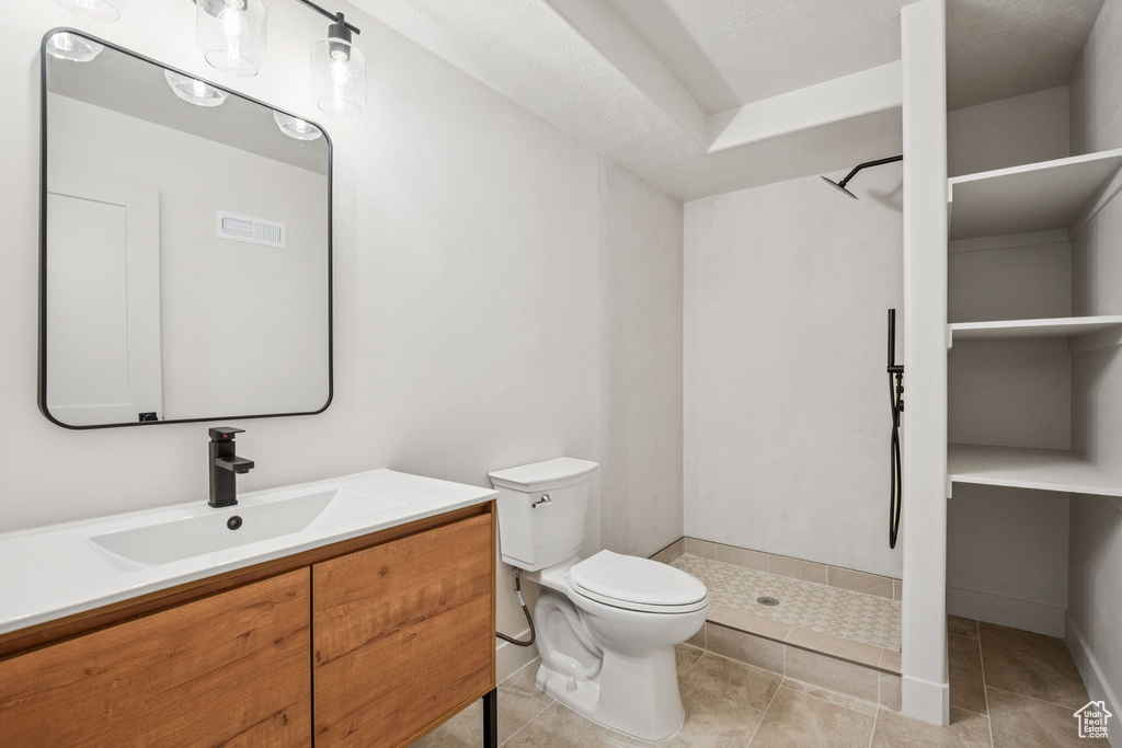 Bathroom featuring a stall shower, vanity, and tile patterned floors