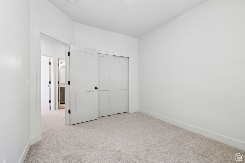 Unfurnished bedroom with carpet flooring and a closet