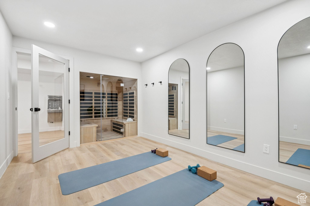 Exercise room featuring wood finished floors, arched walkways, and recessed lighting