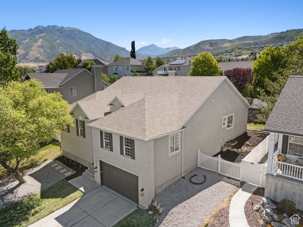 Aerial view of property and surrounding area featuring a mountainous background