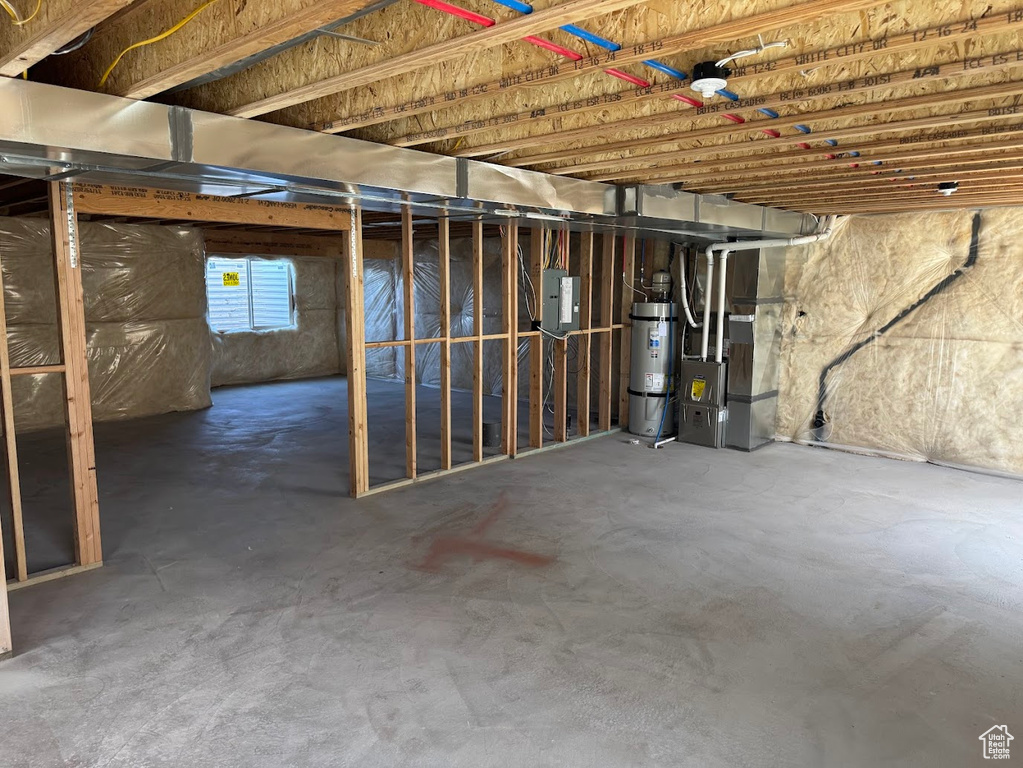 Below grade area with heating unit, water heater, and electric panel