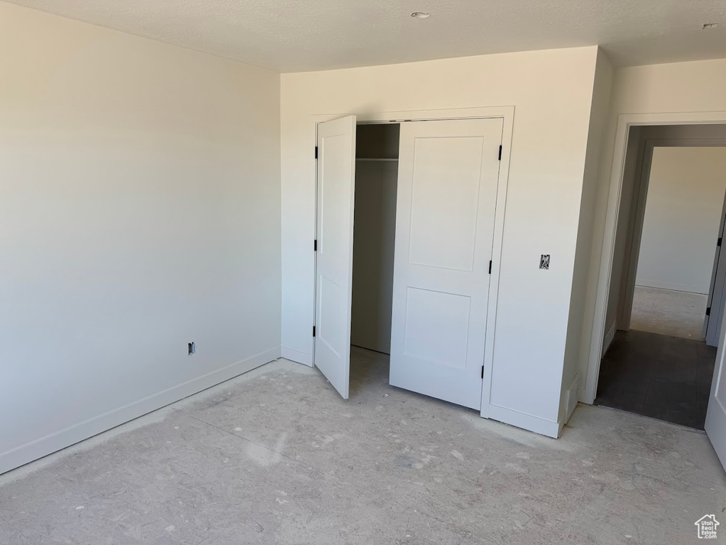 Unfurnished bedroom featuring a closet and baseboards