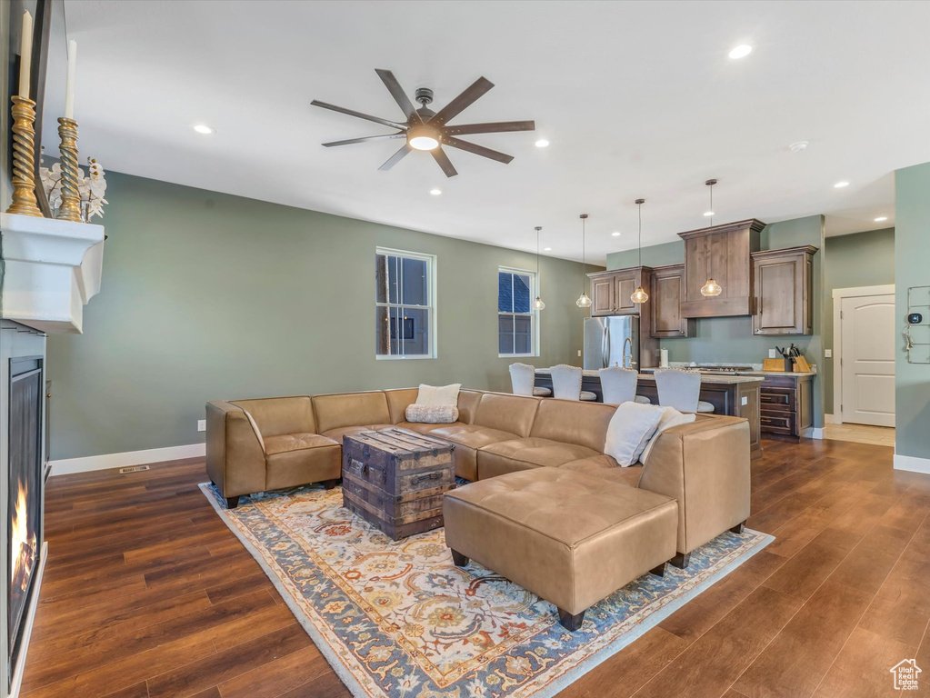Living room featuring a ceiling fan, dark wood finished floors, and recessed lighting