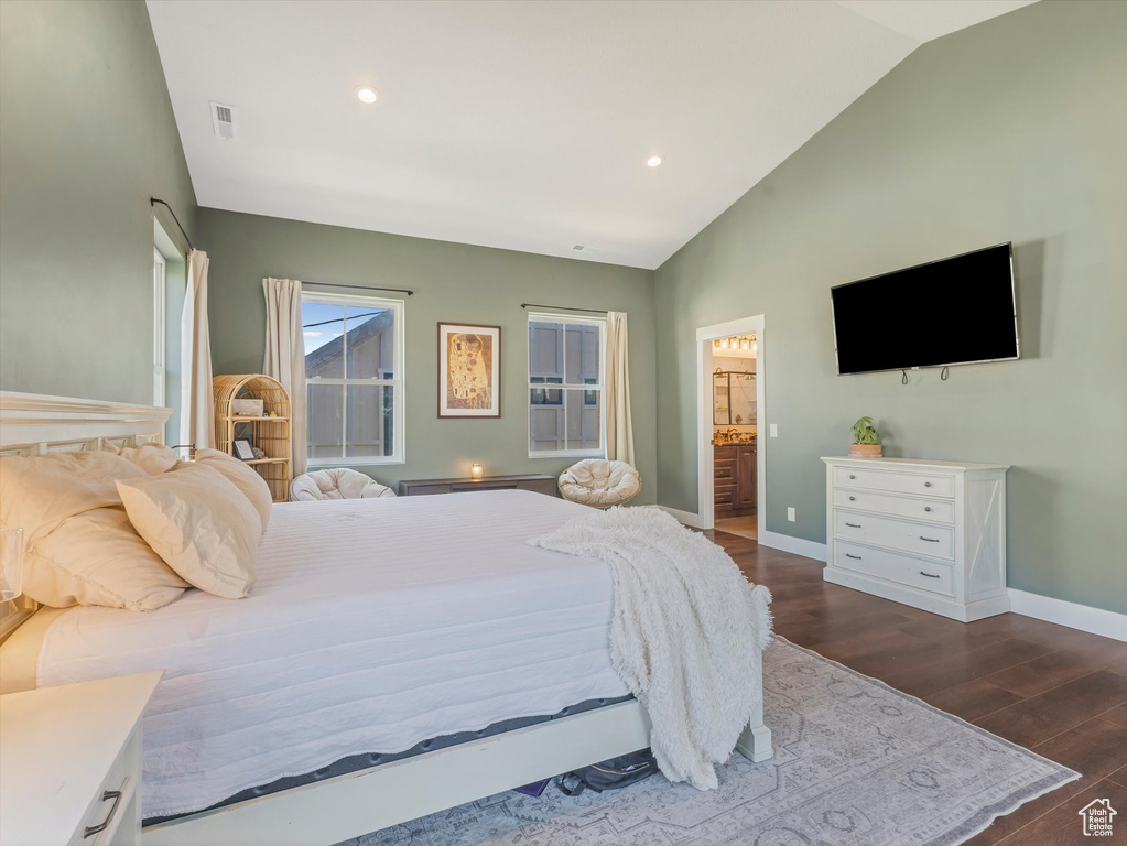 Bedroom featuring vaulted ceiling, dark wood finished floors, recessed lighting, and ensuite bathroom