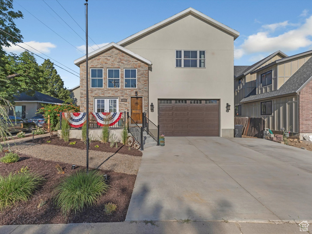 Traditional home with stucco siding, concrete driveway, and a garage