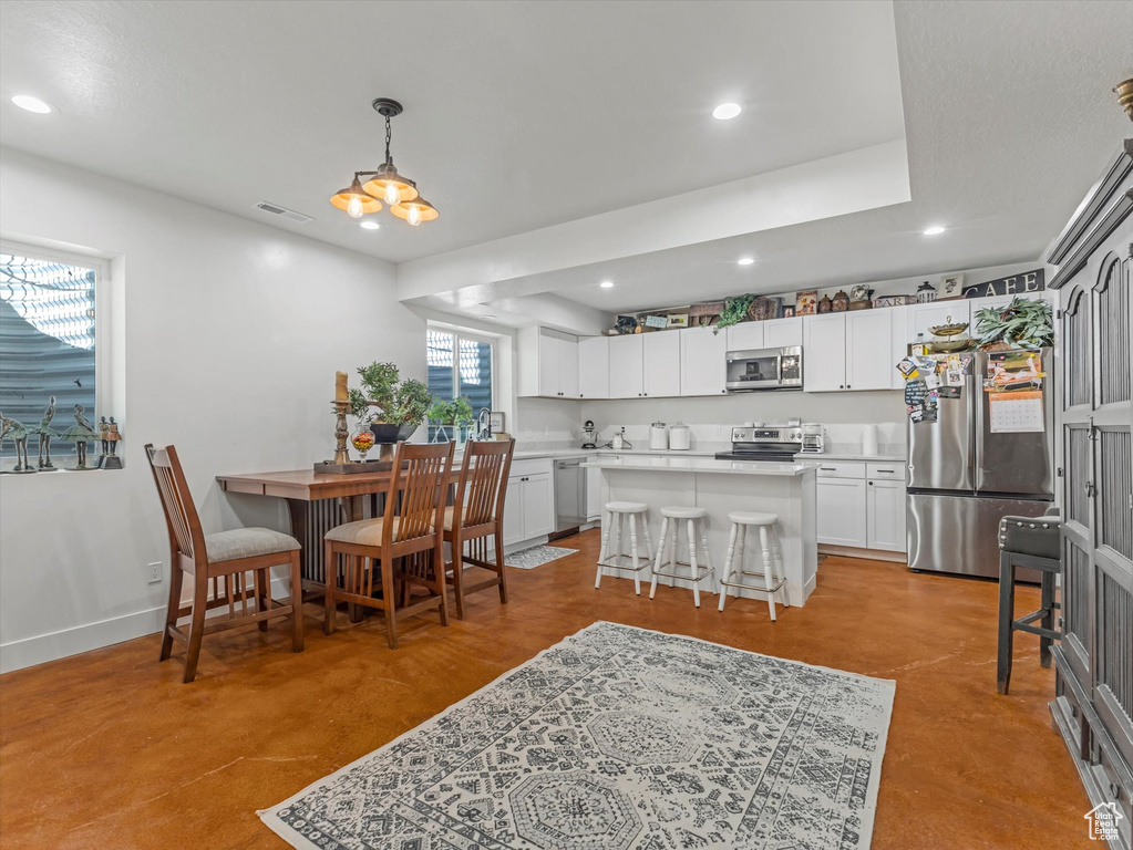 Dining room featuring recessed lighting, finished concrete floors, and a chandelier