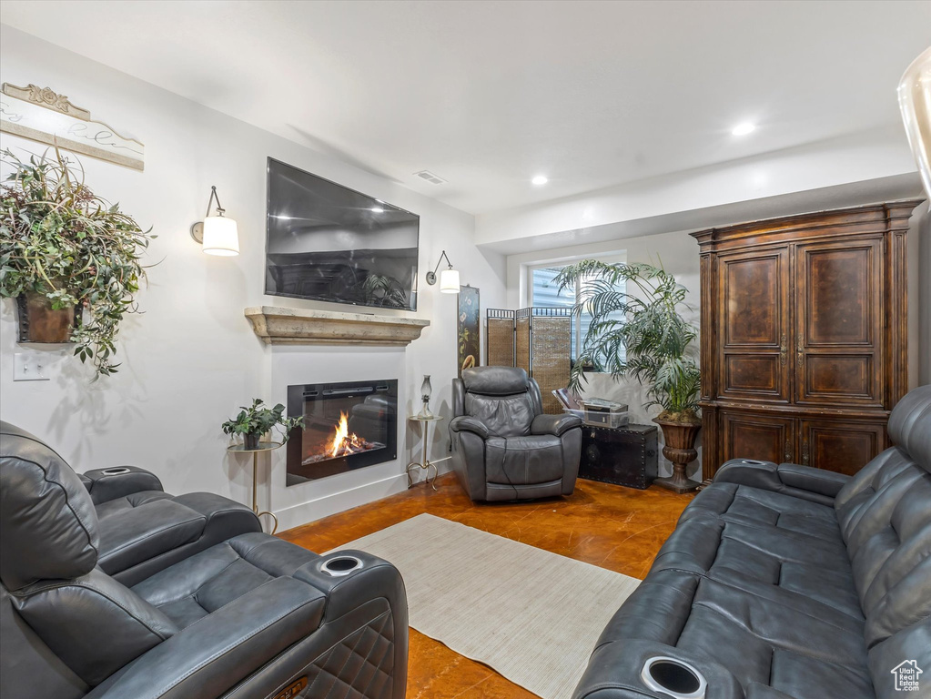 Living room featuring a glass covered fireplace and recessed lighting