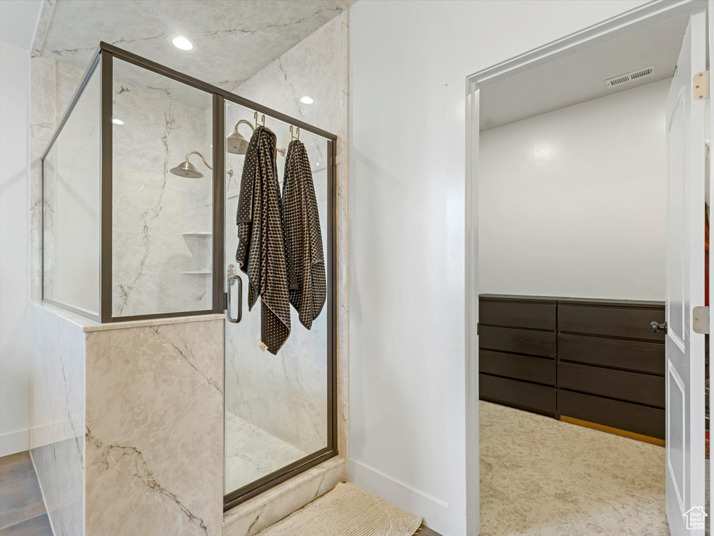 Bathroom featuring a marble finish shower and baseboards
