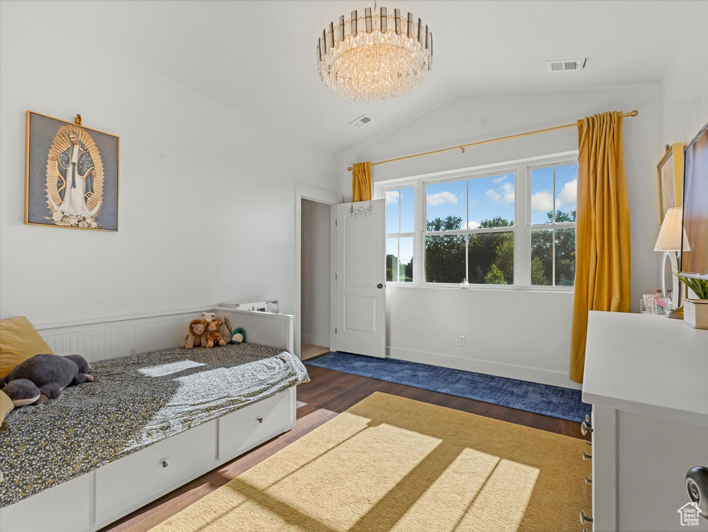 Bedroom featuring wood finished floors and vaulted ceiling