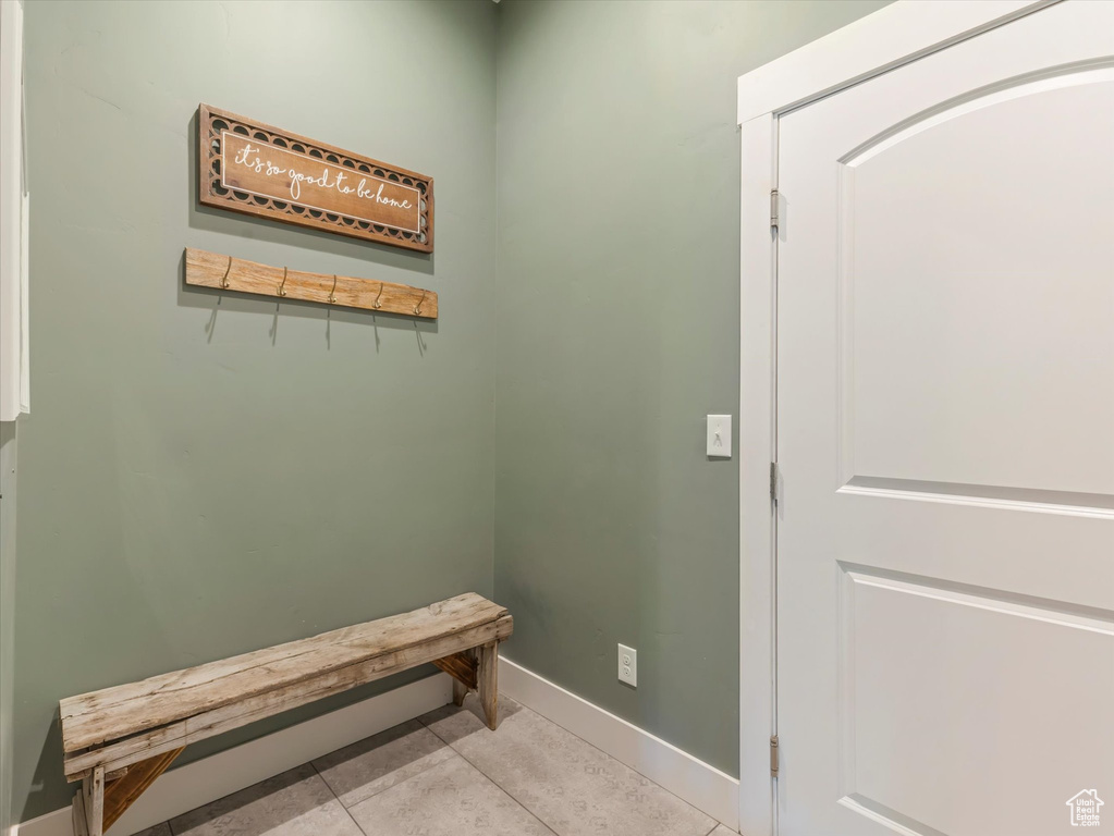 Doorway to outside with baseboards and light tile patterned flooring