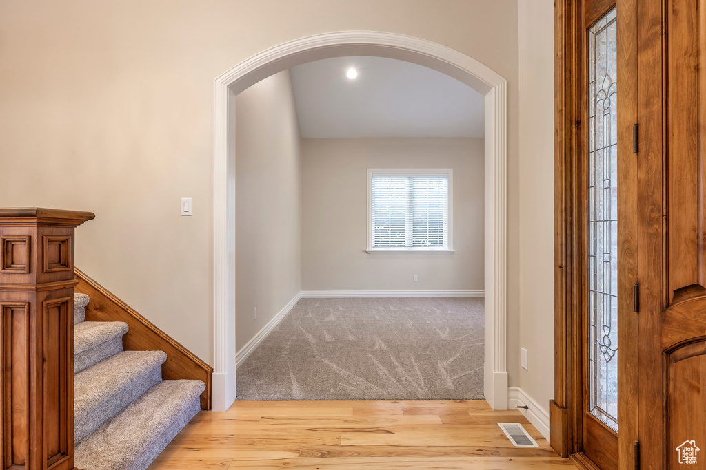 Entrance foyer with arched walkways and wood finished floors