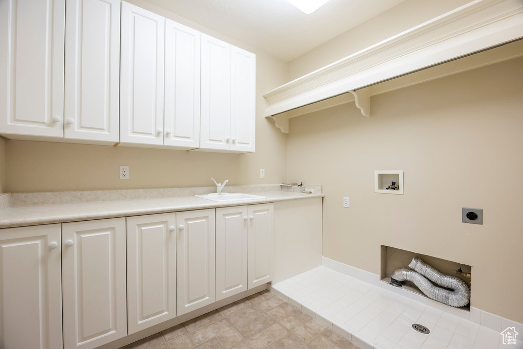 Laundry room with hookup for an electric dryer, cabinet space, and washer hookup