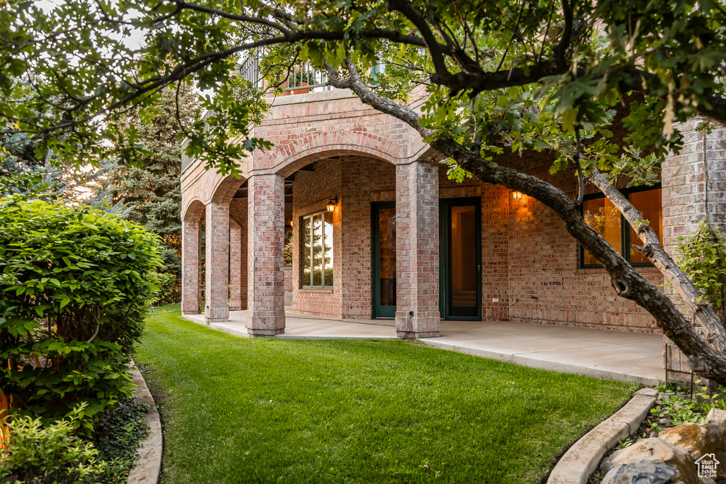 View of front of home featuring brick siding, a front yard, and a porch