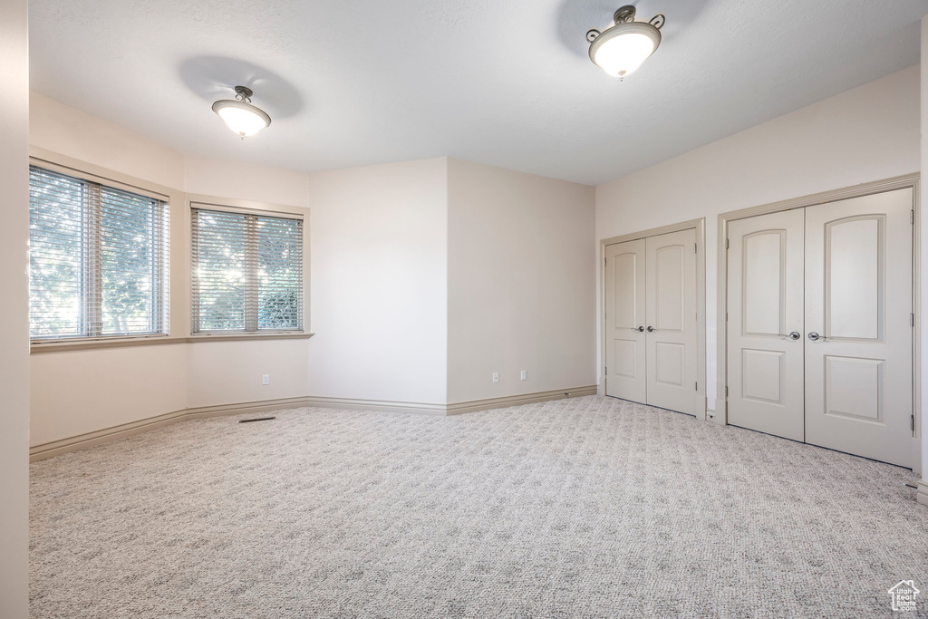 Unfurnished bedroom featuring two closets and carpet flooring