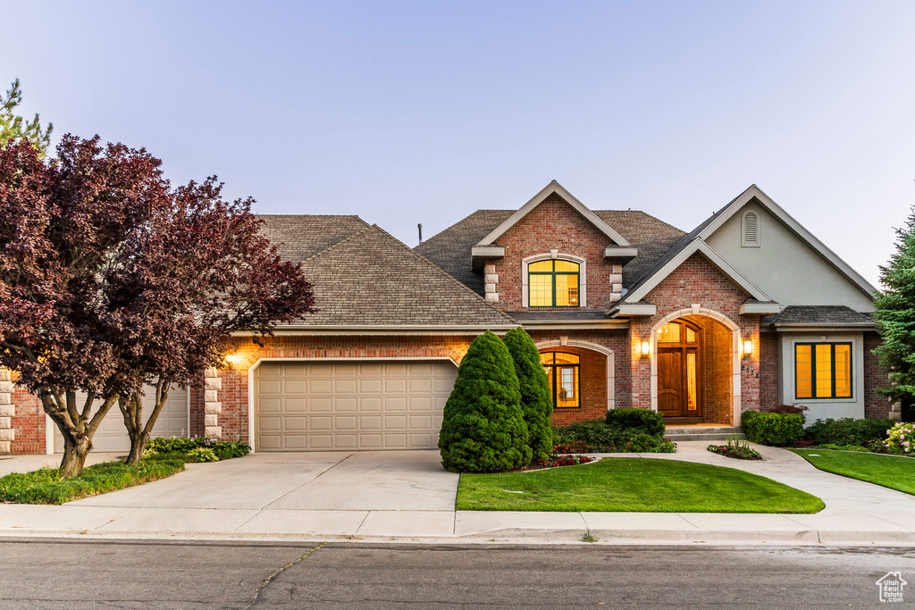 Craftsman inspired home with brick siding, driveway, a garage, and a front yard