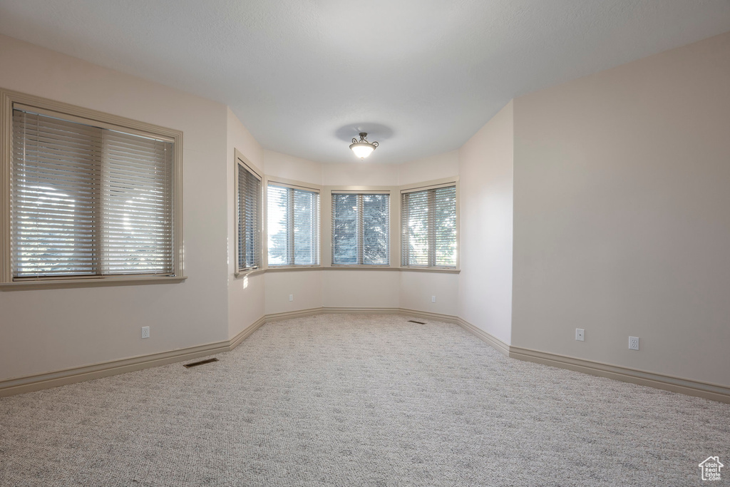 Carpeted empty room featuring baseboards
