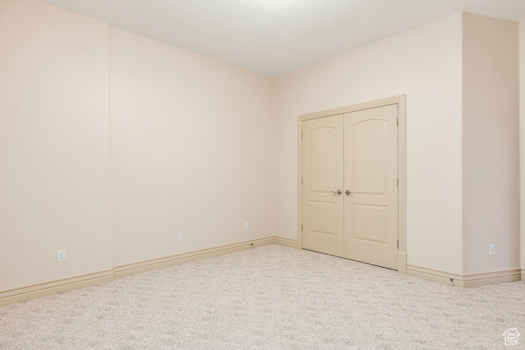 Carpeted empty room featuring baseboards