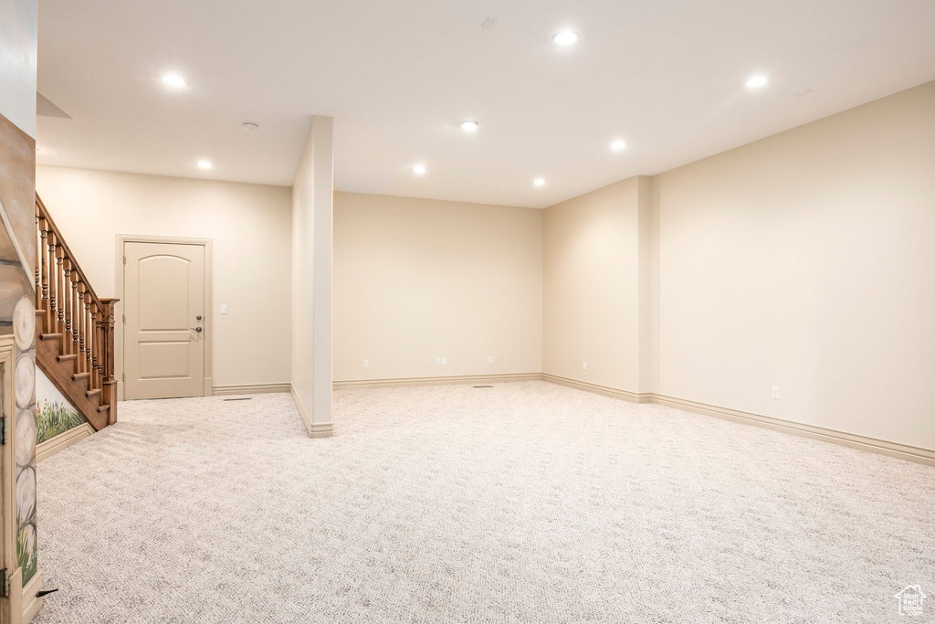 Finished basement with recessed lighting, stairs, and light carpet