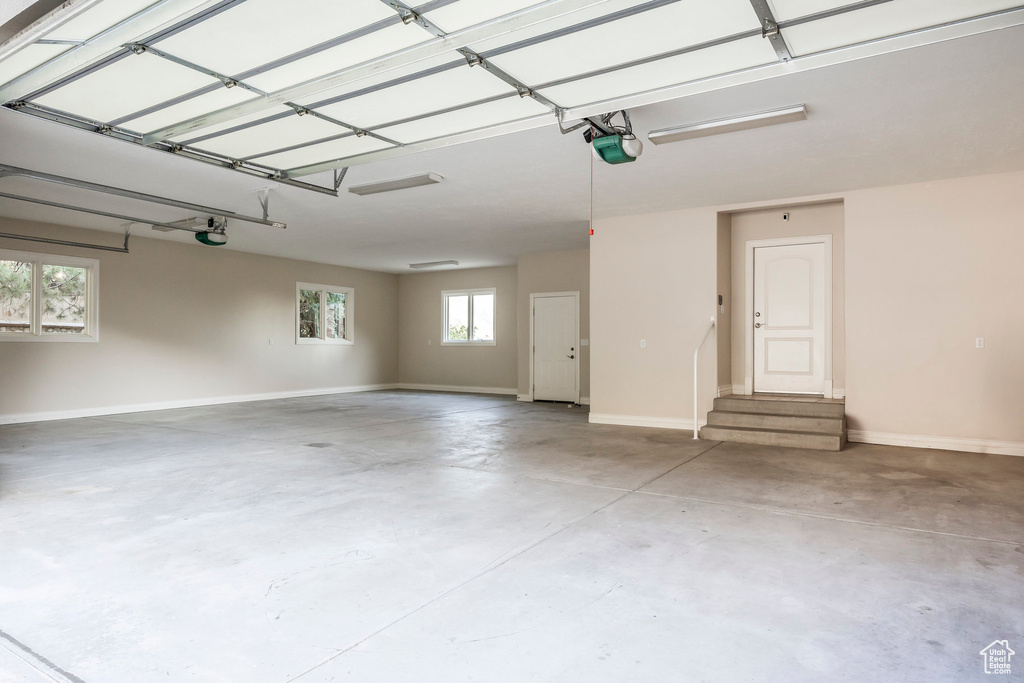 Garage with baseboards and a garage door opener