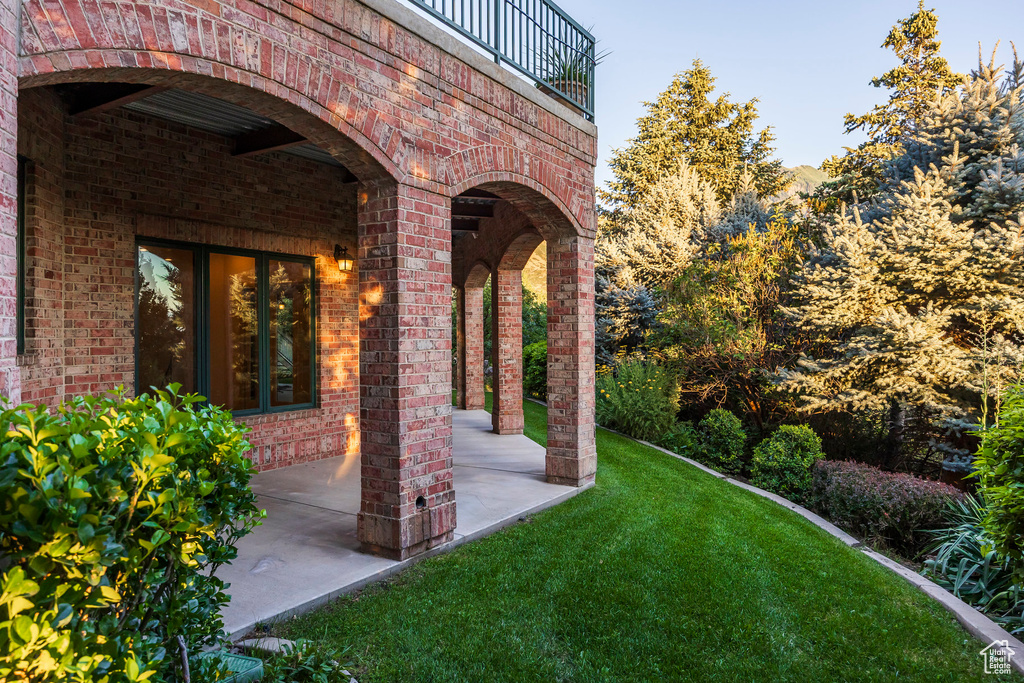 View of grassy yard with a patio area