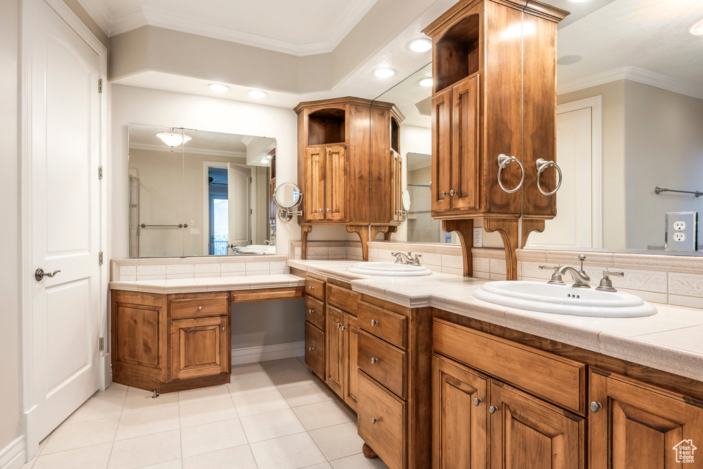 Bathroom with crown molding, double vanity, tile patterned floors, decorative backsplash, and recessed lighting