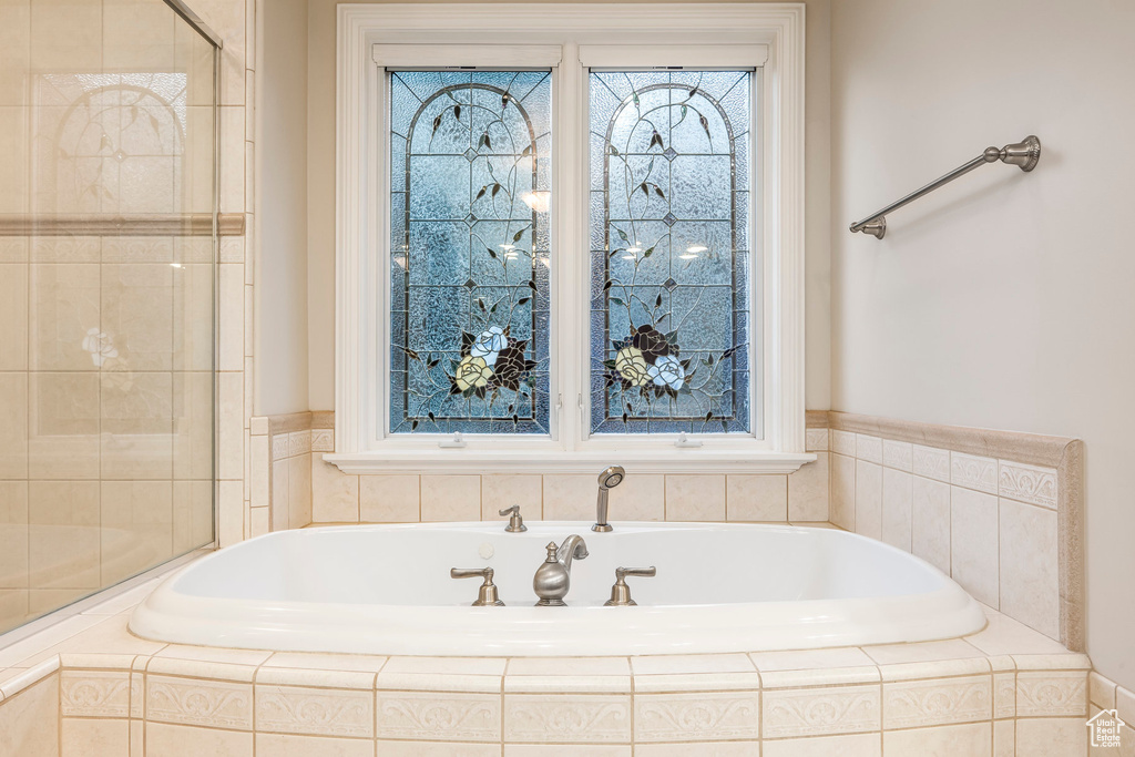 Bathroom featuring a garden tub and tiled shower