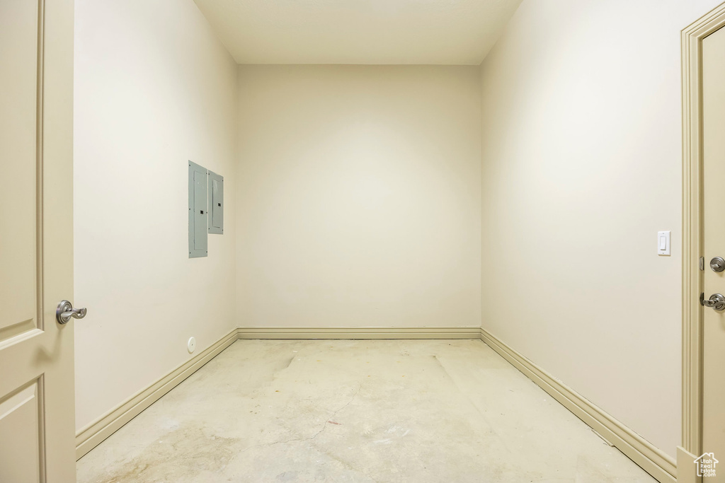 Unfurnished room with concrete flooring and electric panel