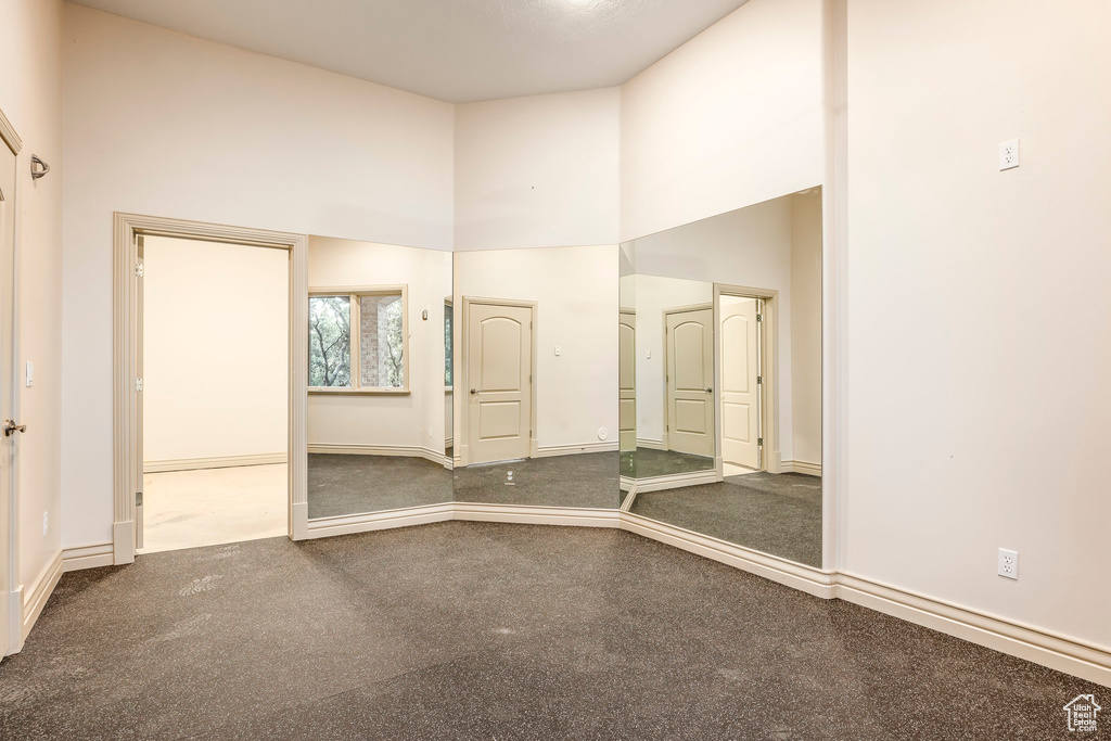 Unfurnished bedroom featuring a high ceiling and baseboards
