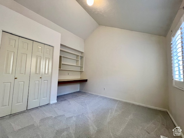 Unfurnished bedroom with carpet floors, vaulted ceiling, and a closet