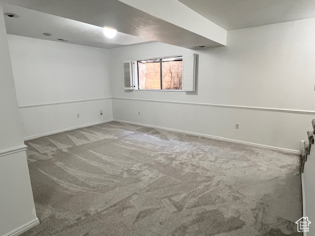 Carpeted spare room with baseboards
