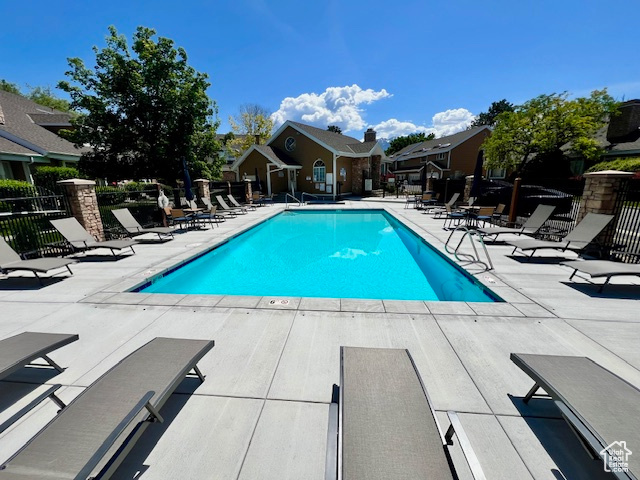 Community pool with a patio and a residential view