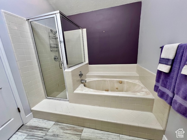 Bathroom with a shower stall and a tub with jets