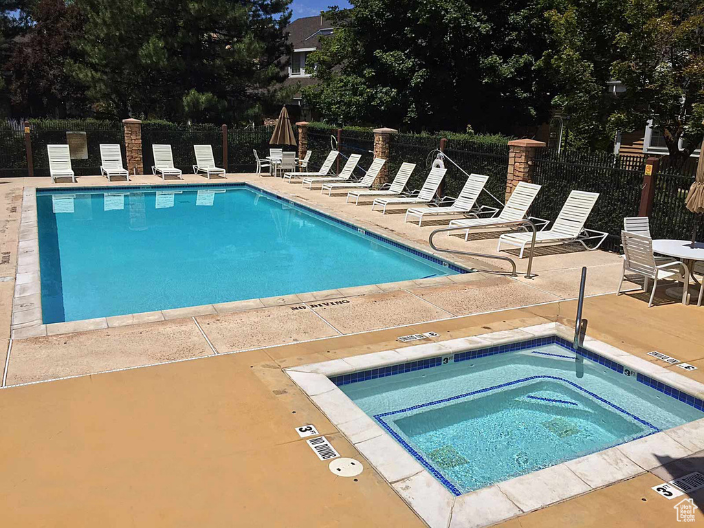 Community pool featuring a patio area and a community hot tub