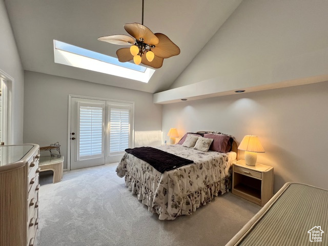 Bedroom with a skylight, vaulted ceiling, access to exterior, carpet, and ceiling fan